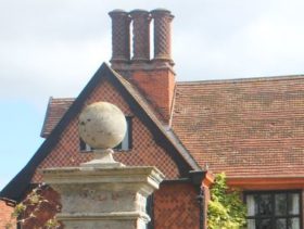 Roof and chimney of an old red brick Hall